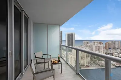 a balcony with a chair and a table and a view at Amazing Pool Infinity View and Gym in Hallandale Beach
