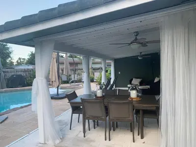 a patio with a table and chairs and a pool at Wilton Manors A Mens Oasis in Fort Lauderdale