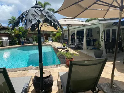 a pool with an umbrella and a table and chairs at Wilton Manors A Mens Oasis in Fort Lauderdale