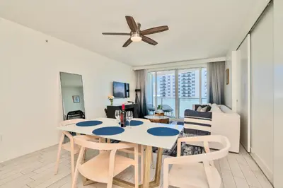 a living room with a dining room table and a ceiling fan at Stylish 1BR Suite with 5 Star Amenities and Stunning Views in Fort Lauderdale