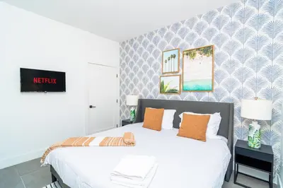 a bedroom with a large white bed with orange pillows at Cozy Miami 2BR Oasis Near Brickell, Calle Ocho & Marlins Stadium in Miami