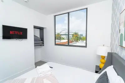 a white bedroom with a bed and a window at Modern Cozy 2BR Oasis with King Beds Near Marlins Park & Brickell in Miami