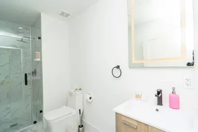 a bathroom with a shower and a toilet and a sink at Modern Cozy 2BR Oasis with King Beds Near Marlins Park & Brickell in Miami