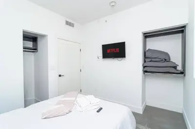 a bedroom with a bed and a clock on the wall at Modern Cozy 2BR Oasis with King Beds Near Marlins Park & Brickell in Miami