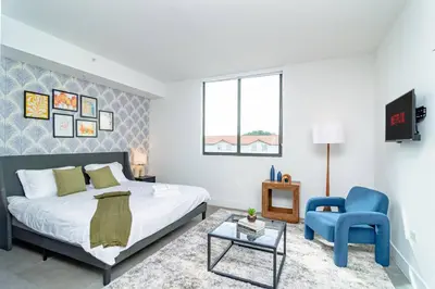 a bedroom with a bed and a blue chair at Central Miami 1BR Suite Close to Beach & Downtown in Miami