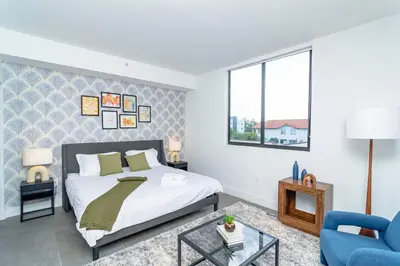 a bedroom with a bed and a blue chair at Central Miami 1BR Suite Close to Beach & Downtown in Miami