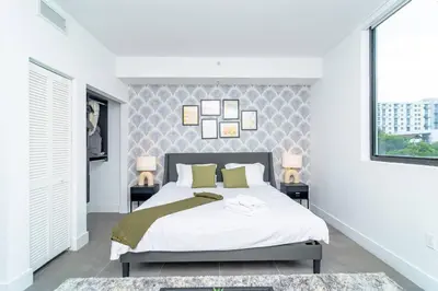 a bedroom with a large bed and two windows at Central Miami 1BR Suite Close to Beach & Downtown in Miami