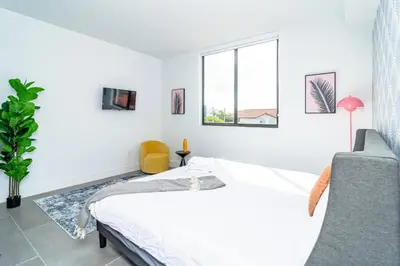 a white bedroom with a bed and a window at Bright 1BR with Netflix and King Bed Near Brickell and Marlins Park in Miami