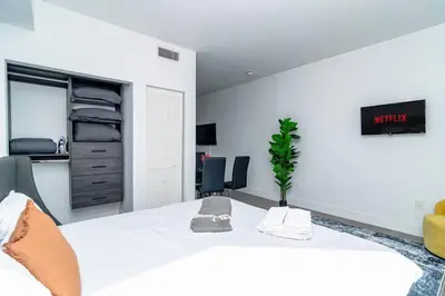 a bedroom with a large white bed and a desk at Bright 1BR with Netflix and King Bed Near Brickell and Marlins Park in Miami