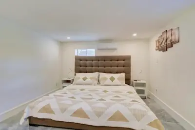 a bedroom with a large bed with a large headboard at Flamingo House with Cinema, Pool & Chill Area in Miami