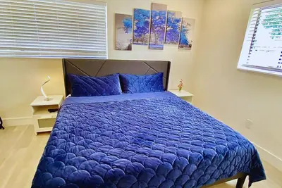 a bedroom with a large blue bed with blue pillows at Flamingo House with Cinema, Pool & Chill Area in Miami
