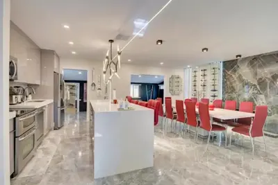 a kitchen with a dining table and red chairs at Flamingo House with Cinema, Pool & Chill Area in Miami