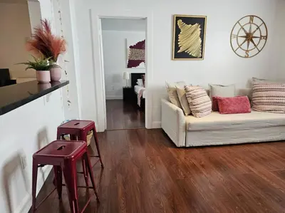 a living room with a white couch and wooden floors at Great 1BedRoom RENOVATED 1 minute from the BEACH in Miami Beach