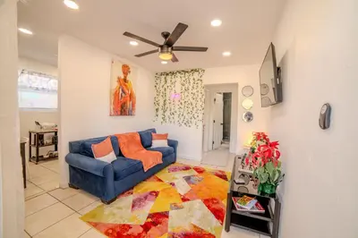 a living room with a blue couch and a rug at Queens Cozy Condo Near Downtown Airport in Miami