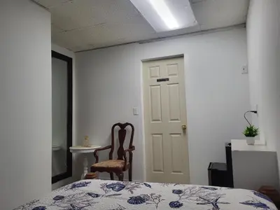 a bedroom with a bed and a chair and a door at Azucar Miami in Miami