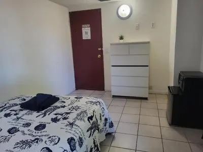 a bedroom with a bed and a dresser and a clock at Azucar Miami in Miami