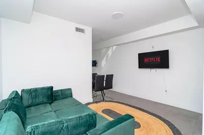 a living room with a green couch and a tv at Chic Spacious Studio Miami Stay Near Marlins Park & Brickell in Miami