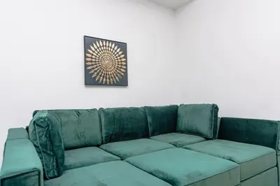 a green couch in a room with a picture on the wall at Chic Spacious Studio Miami Stay Near Marlins Park & Brickell in Miami