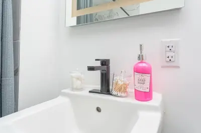 a pink bottle sitting on a sink in a bathroom at Chic Spacious Studio Miami Stay Near Marlins Park & Brickell in Miami