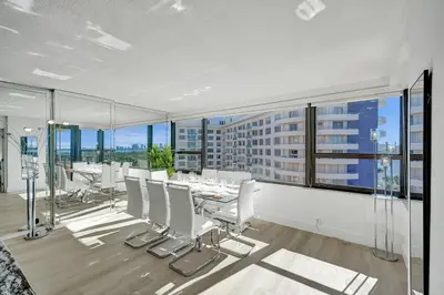 a dining room with a table and white chairs at Luxury Ocean View Condo with Beach Service 1521 in Miami Beach