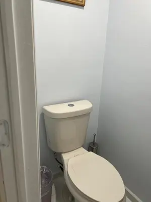 a white toilet in a bathroom with a picture on the wall at Private Studio in West Hialeah in Hialeah