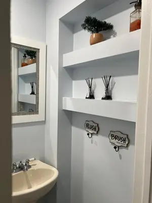 a bathroom with a sink and a toilet and shelves at Private Studio in West Hialeah in Hialeah