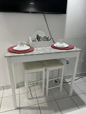 a white table with two plates and cups on it at Private Studio in West Hialeah in Hialeah