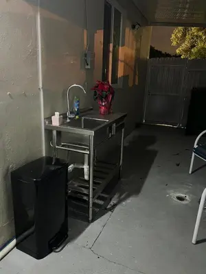 a kitchen sink in a garage next to a wall at Private Studio in West Hialeah in Hialeah
