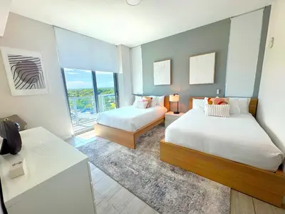 a bedroom with two beds and a large window at Elegant Condo 2BR w Beautiful City Views in Miami