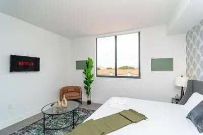 a white bedroom with a bed and a glass table at Central 1BR in Miami with King Bed Near Wynwood and Marlins Park in Miami