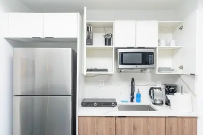 a kitchen with white cabinets and a stainless steel refrigerator at Central 1BR in Miami with King Bed Near Wynwood and Marlins Park in Miami