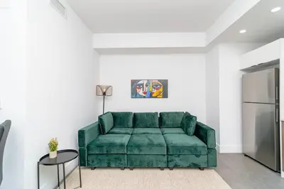 a green couch in a living room with a refrigerator at Central 1BR in Miami with King Bed Near Wynwood and Marlins Park in Miami