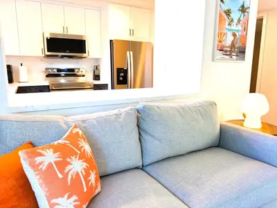 a blue couch with orange pillows in a living room at Homey Haven in Vibrant South Beach in Miami Beach