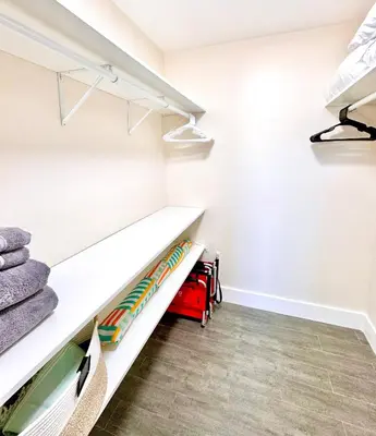 a walk in closet with white shelves and towels at Homey Haven in Vibrant South Beach in Miami Beach