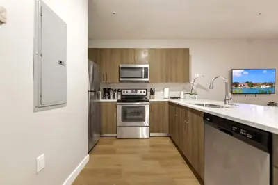 a kitchen with stainless steel appliances and wooden cabinets at Spacious 3BR Townhouse with Free Parking Included! in Miami