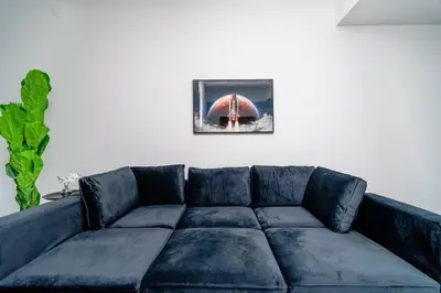a blue couch in a living room with a picture on the wall at Beautiful 1BR in Little Havana Close with King Bed Near Brickell & Marlins Park in Miami