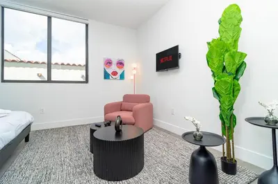a living room with a pink chair and a table at Beautiful 1BR in Little Havana Close with King Bed Near Brickell & Marlins Park in Miami