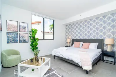 a bedroom with a bed and a chair and a table at Centrally Located 1BR with King Bed Near Brickell, Airport Downtown and Wynwood in Miami
