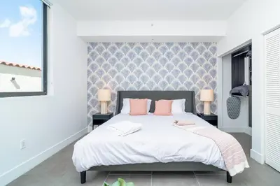 a bedroom with a large bed with pink pillows at Centrally Located 1BR with King Bed Near Brickell, Airport Downtown and Wynwood in Miami