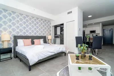 a bedroom with a bed and a table with chairs at Centrally Located 1BR with King Bed Near Brickell, Airport Downtown and Wynwood in Miami