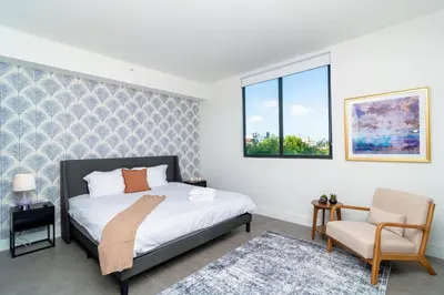 a bedroom with a bed and a chair and a window at Well Located 1BR with King Bed, Laundry and Parking Option Near Brickell and Marlins Park in Miami