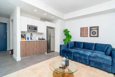 a living room with a blue couch and a table at Well Located 1BR with King Bed, Laundry and Parking Option Near Brickell and Marlins Park in Miami
