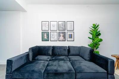 a blue couch in a living room with pictures on the wall at Miami 1BR New Oasis with King Bed Near Brickell & Marlins Park in Miami