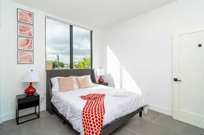 a bedroom with a bed with a red and white blanket on it at Miami 2BR Getaway with King Beds Near Marlins Park & Calle Ocho in Miami