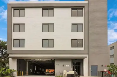 a large white building with a parking garage at Miami 2BR Getaway with King Beds Near Marlins Park & Calle Ocho in Miami