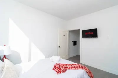 a white bedroom with a bed with a red and white blanket on it at Miami 2BR Getaway with King Beds Near Marlins Park & Calle Ocho in Miami