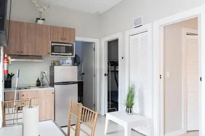a kitchen with a white refrigerator and wooden cabinets at Anselmo Brickell Apartments in Miami