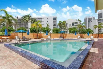 a large swimming pool with chairs and umbrellas at Skyline Paradise in Sunny Isles Beach in Sunny Isles Beach
