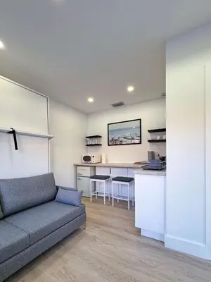 a living room with a couch and a kitchen at Quiet Shenandoah Retreat, Central Miami in Miami