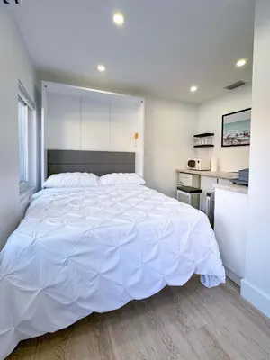 a large white bed in a room with a kitchen at Quiet Shenandoah Retreat, Central Miami in Miami